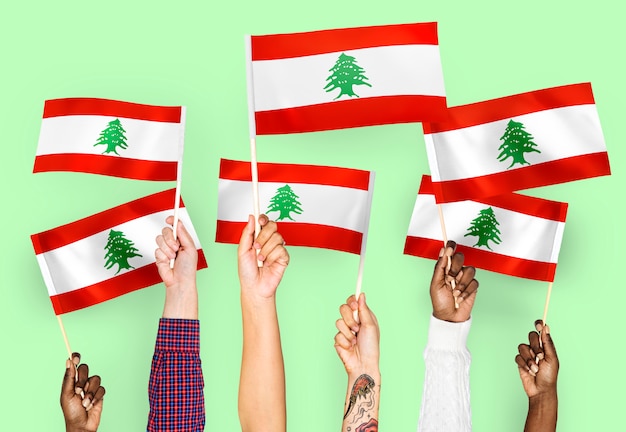 Free photo hands waving flags of lebanon