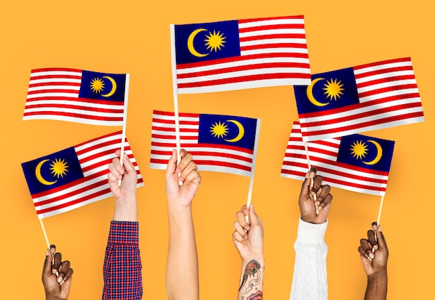 Free photo hands waving flags of malaysia