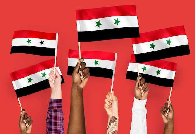 Free photo hands waving flags of syria