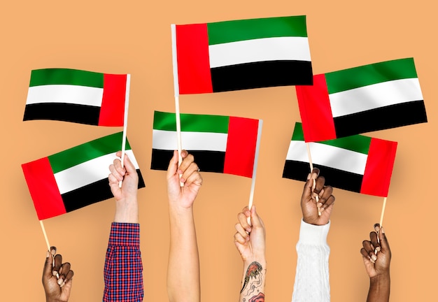 Free Photo hands waving flags of the united arab emirates