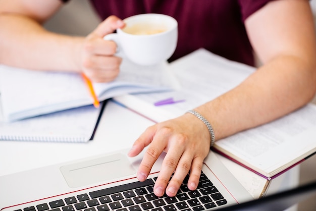 Free photo hands with cup and laptop on table