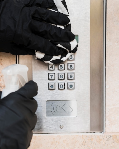 Hands with gloves disinfecting interphone