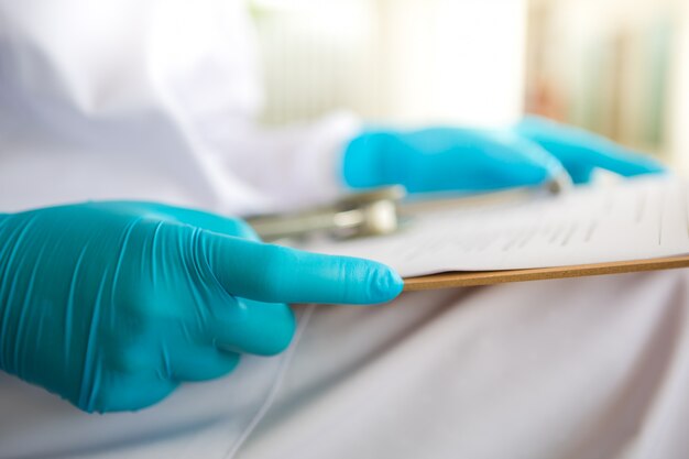 Hands with latex gloves holding a clipboard