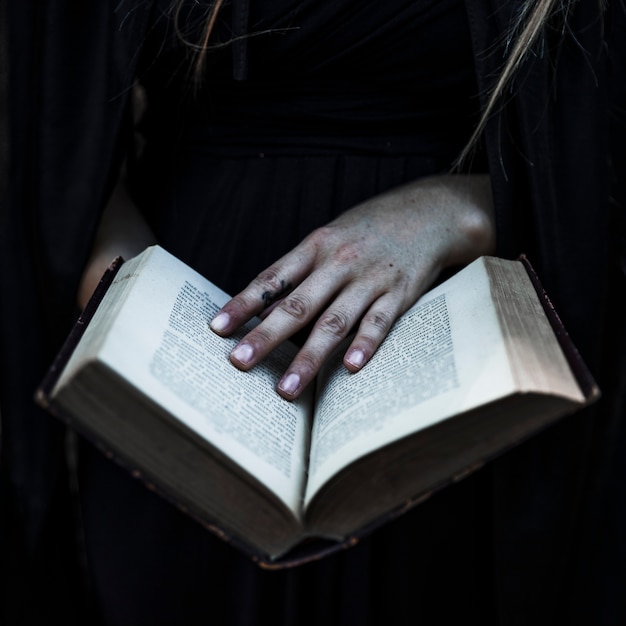 Free Photo hands of woman in black clothes holding opened book