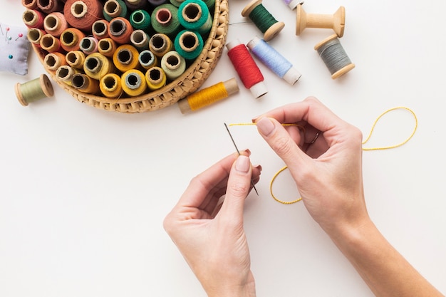 Hands working with needle and sewing thread