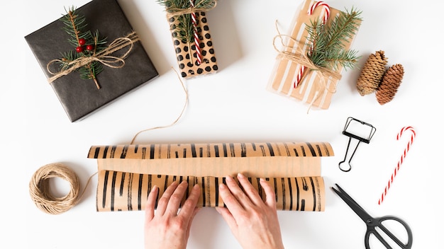 Free photo hands wrapping christmas present in packing paper