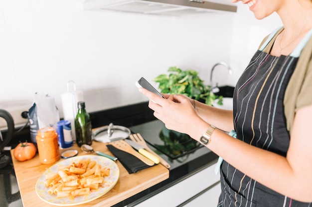 Free photo hands young woman taking photo of delicious pasta on smartphone