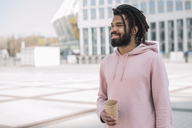 Free photo handsome afroamerican man holding coffee