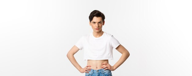 Handsome androgynous man in crop top looking confident at camera holding hands on waist lgbtq activi