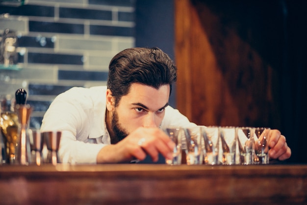 Handsome bartender man making drinking and cocktails at a counter