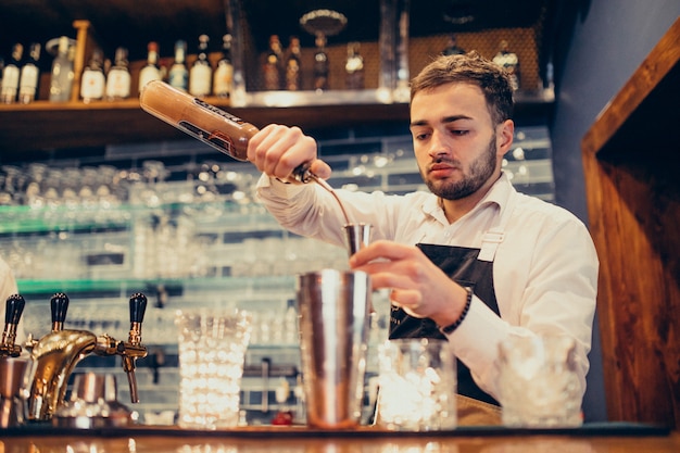 Free photo handsome bartender man making drinking and cocktails at a counter