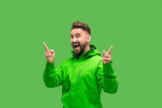 Free Photo handsome bearded smiling happy young man looking at front isolated on vivid trendy green studio