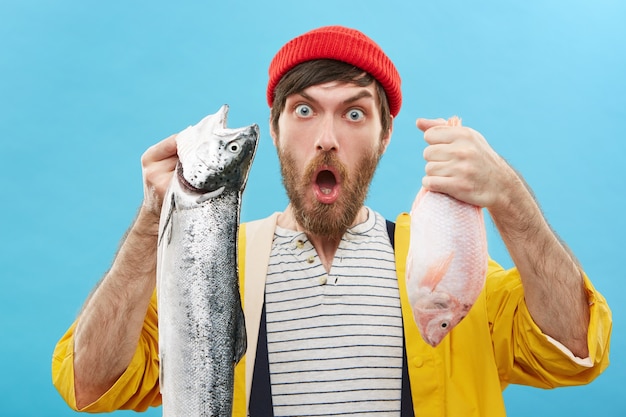 Free Photo handsome bearded young angler holding two fish he just caught