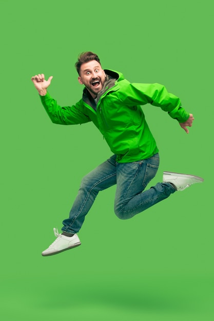 Free photo handsome bearded young man running isolated on green