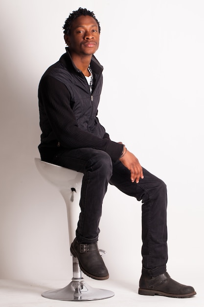 Free photo handsome black guy sitting on a chair