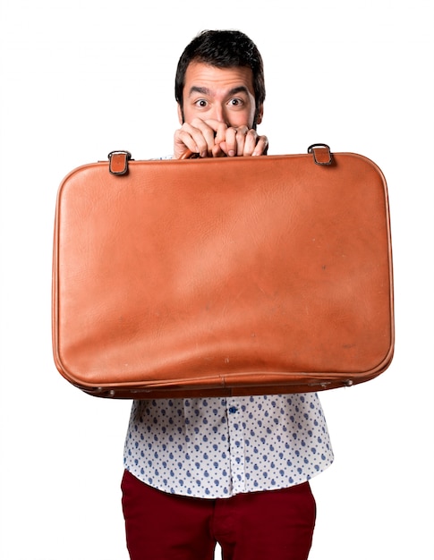 Free Photo handsome brunette man with beard holding a vintage  briefcase