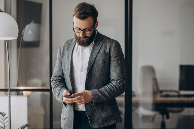 Handsome business man using phone at the office