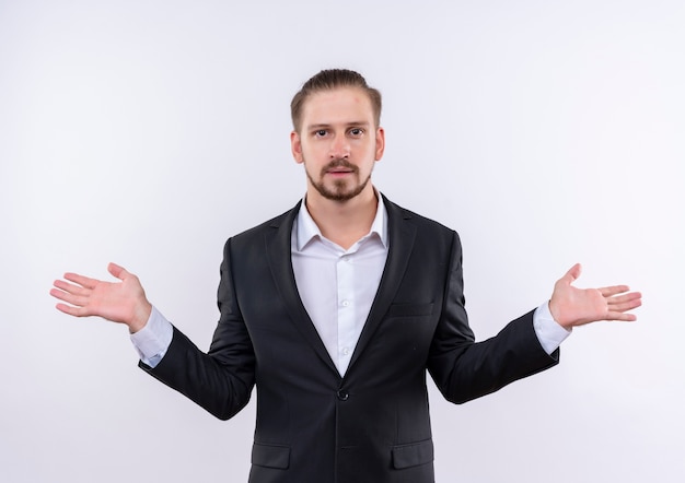 Free photo handsome business man wearing suit looking confused shrugging shoulders standing over white background