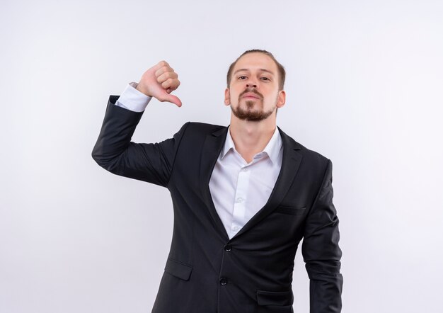 Handsome business man wearing suit pointng with finger to himself self-confident and proud standing over white background