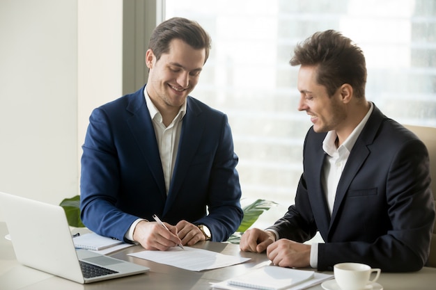 Free Photo handsome businessman signing contract with partner