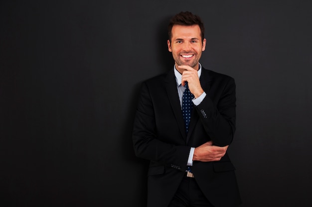 Handsome businessman standing at the blackboard