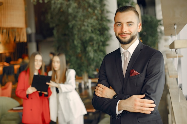 Free photo handsome businessman with women standing and working in a cafe