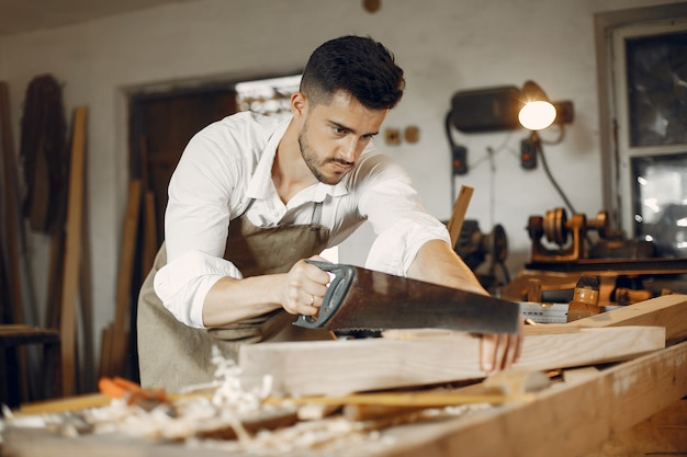 Handsome carpenter working with a wood