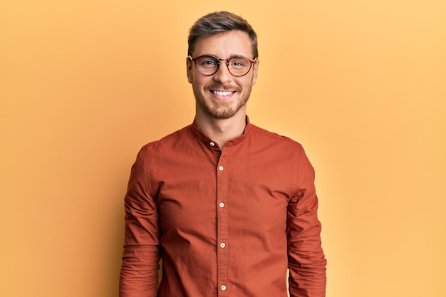 Handsome caucasian man wearing casual clothes and glasses with a happy and cool smile on face. lucky person.