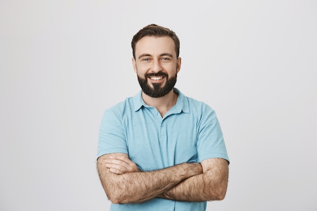 Handsome confident smiling man with hands crossed on chest