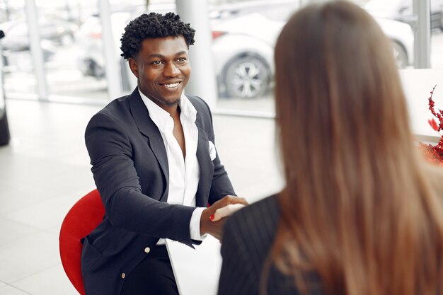 Handsome and elegant black man in a car salon