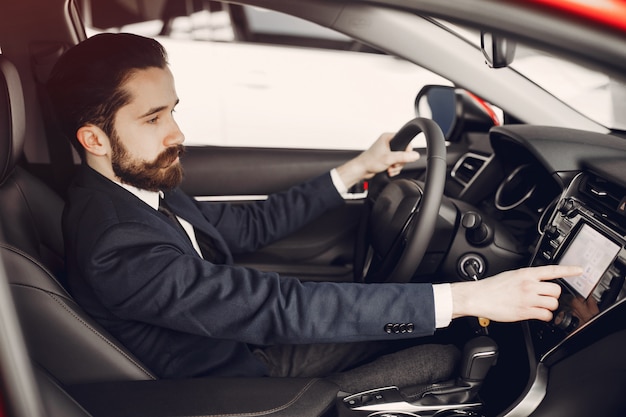 Handsome and elegant man in a car salon