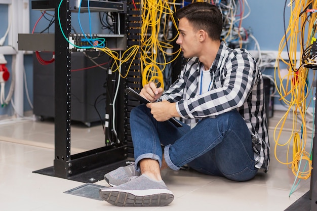 Free Photo handsome engineer working in server room