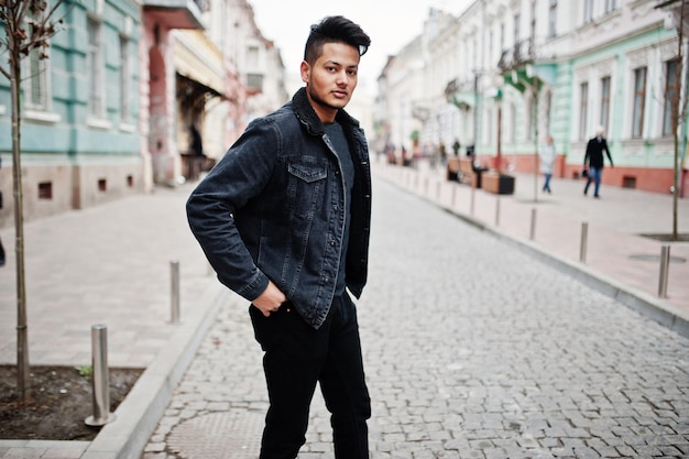 Handsome and fashionable indian man in black jeans jacket posed outdoor