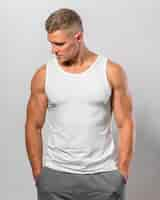 Free photo handsome fit man posing while wearing tank top