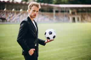 Free photo handsome football player at stadium in business suit