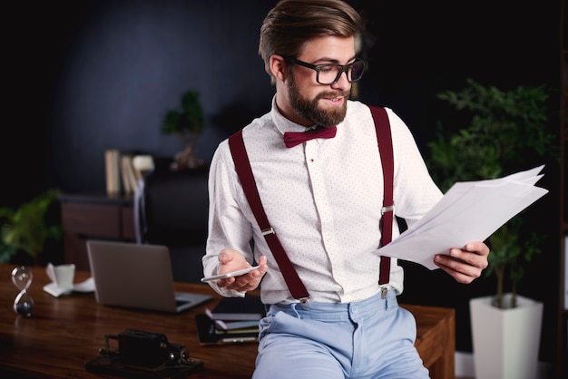 Free photo handsome freelancer reading documents at home office