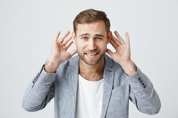 Handsome guy can't hear anything, hold hands near ears