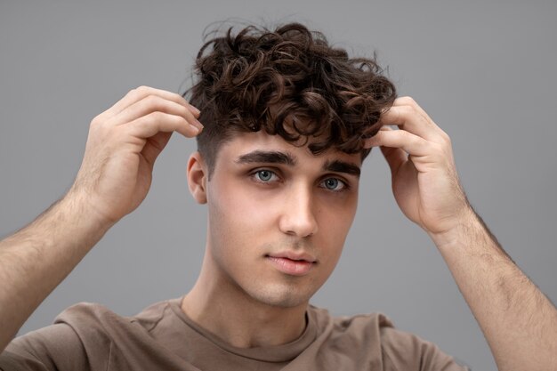 Handsome guy fixing his curly hair