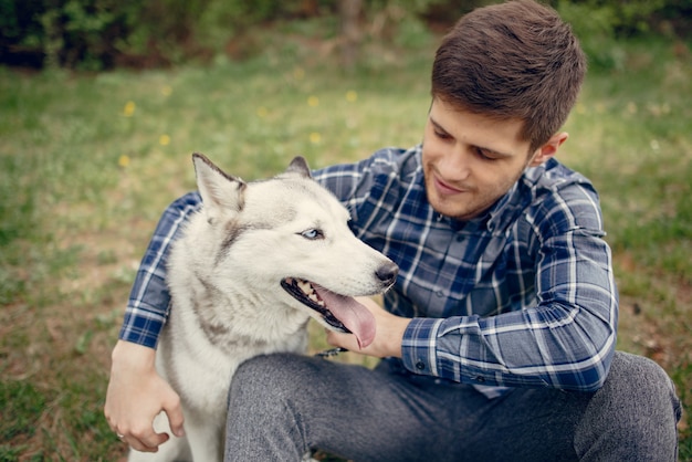 Free Photo handsome guy in a summer park with a dog