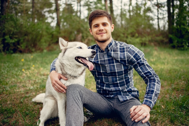 Free Photo handsome guy in a summer park with a dog