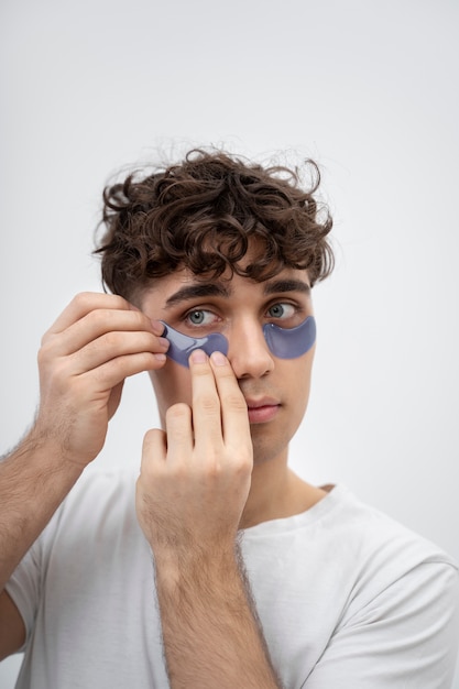 Handsome guy using pads under his eyes