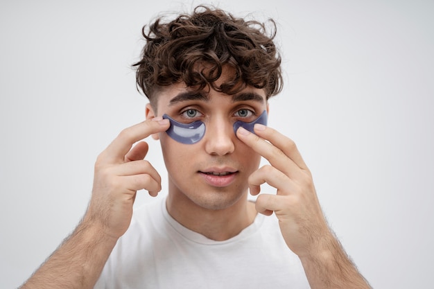 Free Photo handsome guy using pads under his eyes