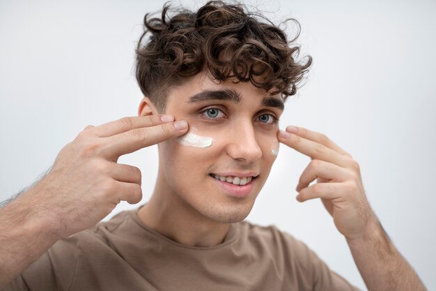 Handsome guy with lotion on his face