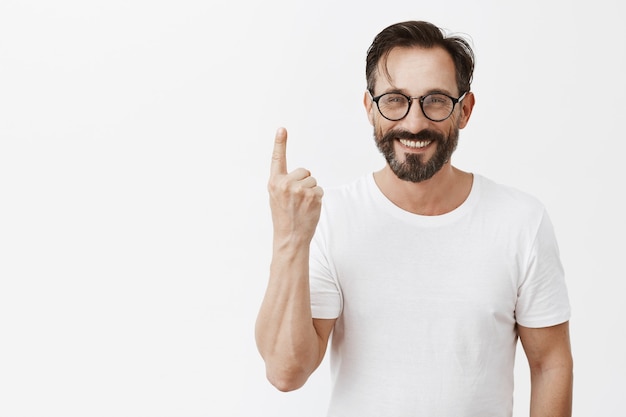 Handsome happy bearded mature man with glasses posing