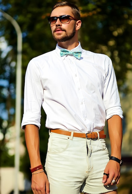 Free photo handsome hipster model man in stylish summer clothes posing in sunglasses