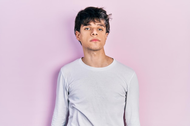 Free Photo handsome hipster young man wearing casual white shirt relaxed with serious expression on face simple and natural looking at the camera