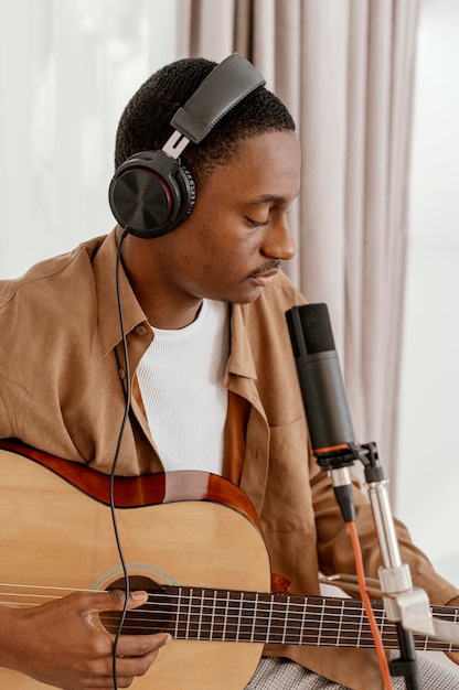 Free Photo handsome male musician at home playing guitar