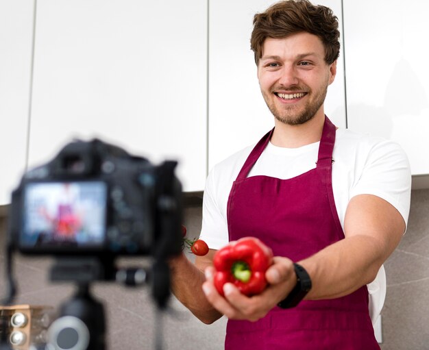 Handsome male recording cooking video at home