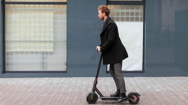 Free photo handsome male riding an electric scooter