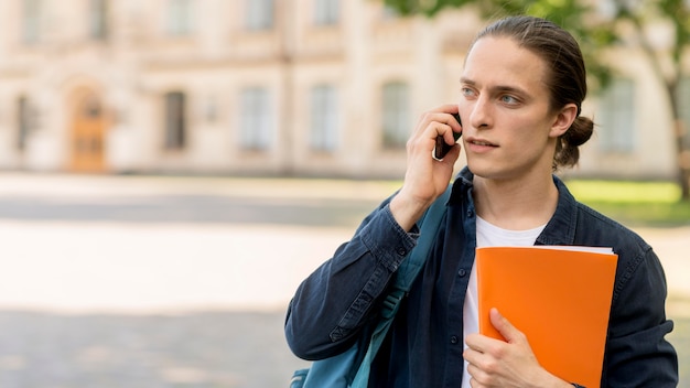 Handsome male student talking on the phone